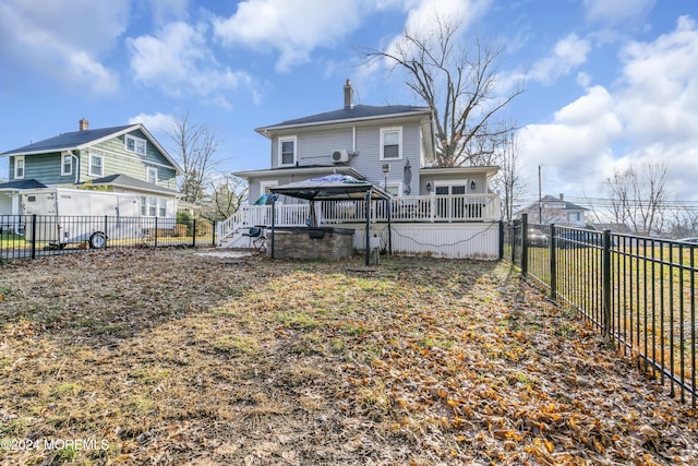 rear view of house featuring a gazebo and a deck