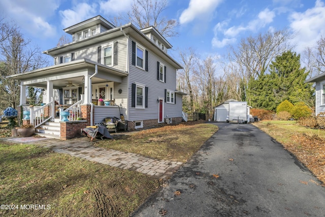 view of front of house featuring covered porch, a garage, and an outdoor structure