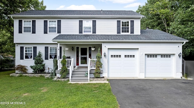 view of front of house featuring a garage, covered porch, and a front yard