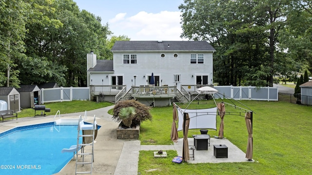 view of swimming pool with an outdoor hangout area, a wooden deck, a water slide, a patio, and a storage unit