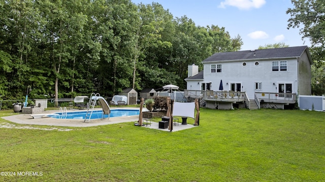 back of house featuring a swimming pool side deck, a yard, and a storage unit