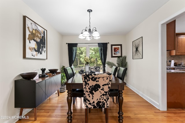 dining space with a chandelier and light hardwood / wood-style floors