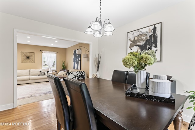 dining space featuring hardwood / wood-style floors and an inviting chandelier