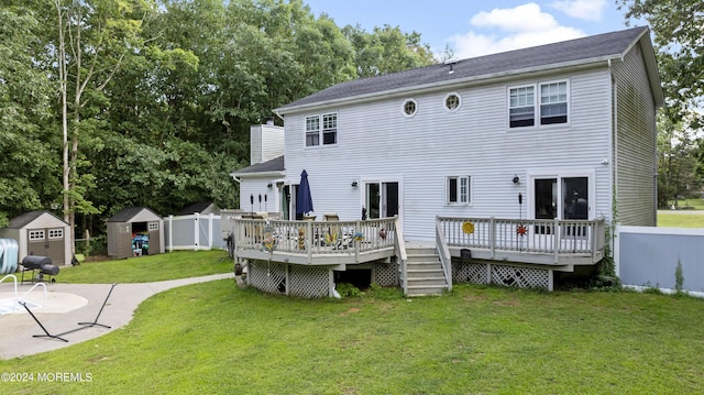 rear view of house featuring a deck, a storage unit, and a lawn