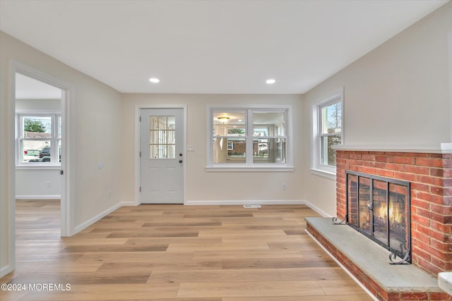 entrance foyer featuring a fireplace and light wood-type flooring