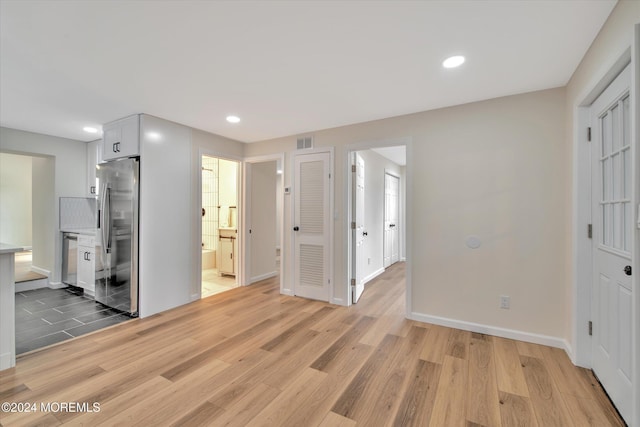 interior space with white cabinetry, light wood-type flooring, and appliances with stainless steel finishes