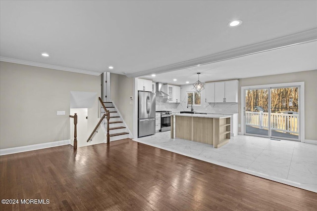 kitchen with hanging light fixtures, stainless steel appliances, a kitchen island, light hardwood / wood-style flooring, and white cabinets