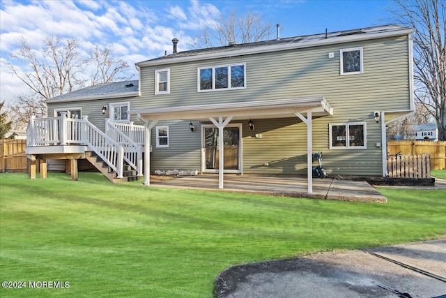 back of property with solar panels, a deck, a patio area, and a lawn