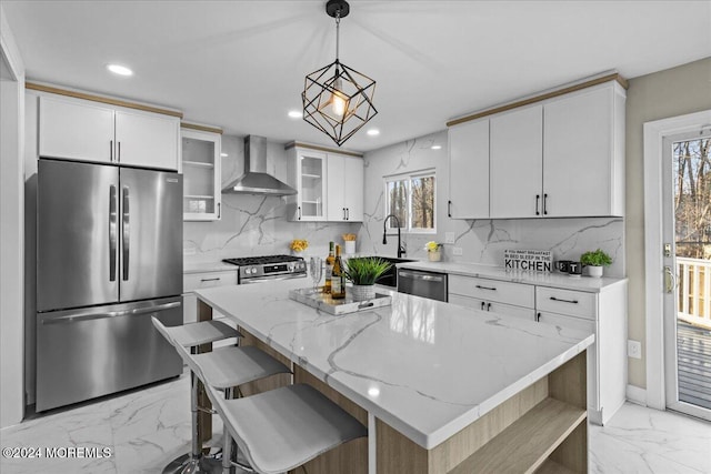 kitchen with white cabinetry, a center island, wall chimney exhaust hood, and stainless steel appliances