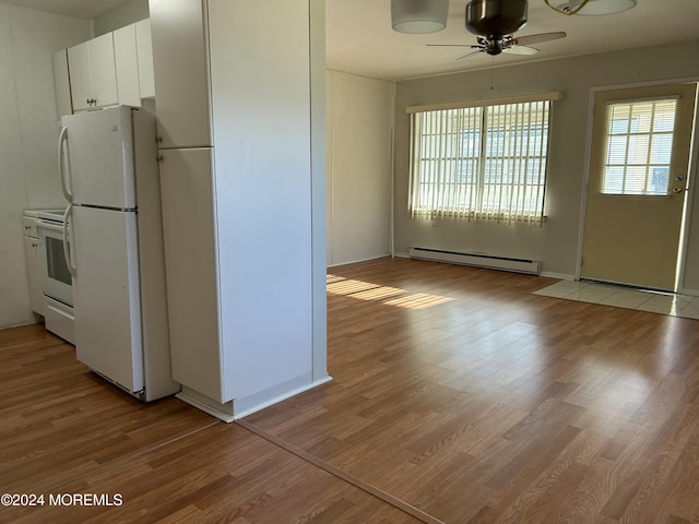 kitchen with stove, ceiling fan, a baseboard radiator, white fridge, and white cabinetry