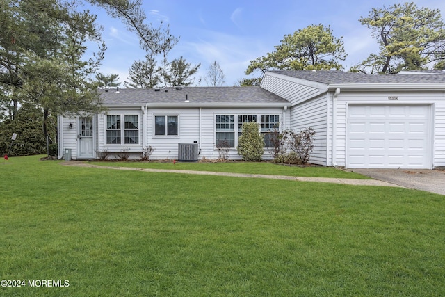 single story home featuring a front lawn, a garage, and central AC unit