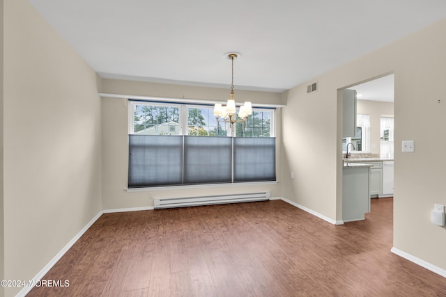 unfurnished dining area with baseboard heating, hardwood / wood-style flooring, plenty of natural light, and a notable chandelier