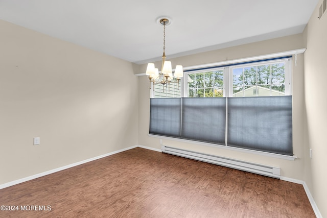 unfurnished dining area featuring an inviting chandelier and a baseboard heating unit