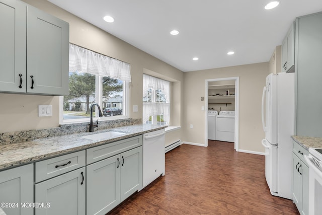 kitchen featuring washing machine and clothes dryer, sink, a baseboard radiator, built in features, and white appliances