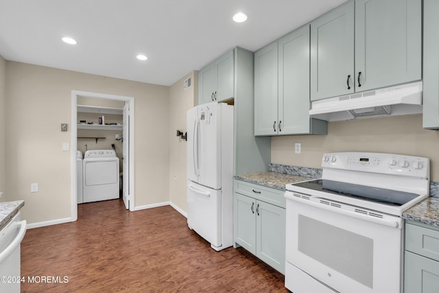 kitchen with washing machine and dryer, light stone countertops, dark hardwood / wood-style floors, and white appliances