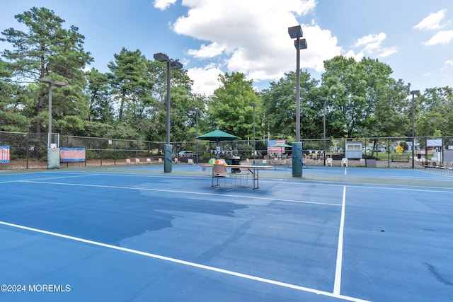 view of tennis court featuring basketball hoop