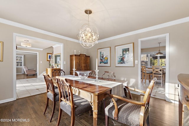 dining room featuring dark hardwood / wood-style floors, ornamental molding, and an inviting chandelier