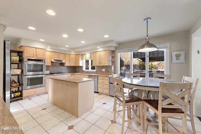 kitchen featuring backsplash, decorative light fixtures, stainless steel appliances, and light brown cabinetry