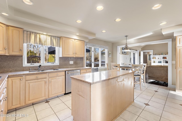 kitchen featuring pendant lighting, light brown cabinets, sink, stainless steel dishwasher, and plenty of natural light