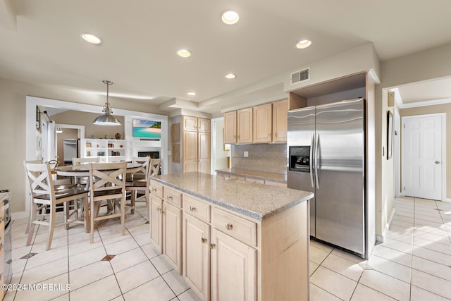 kitchen featuring light brown cabinets, a center island, hanging light fixtures, tasteful backsplash, and stainless steel refrigerator with ice dispenser