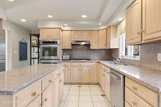 kitchen with sink, stainless steel appliances, backsplash, light brown cabinetry, and light tile patterned floors