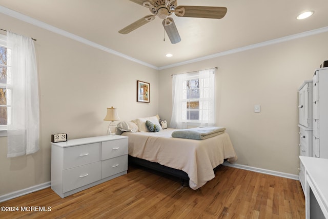 bedroom featuring multiple windows, ceiling fan, light hardwood / wood-style flooring, and crown molding