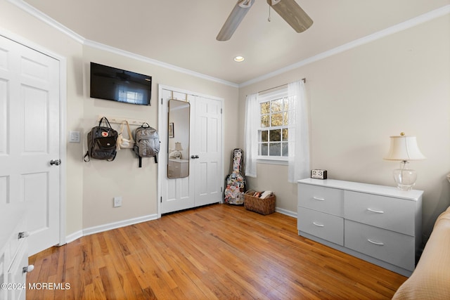 bedroom with ceiling fan, light hardwood / wood-style floors, ornamental molding, and a closet