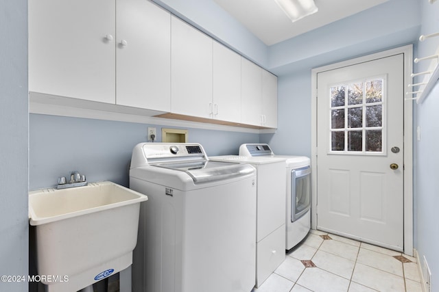 clothes washing area featuring sink, light tile patterned floors, cabinets, and independent washer and dryer