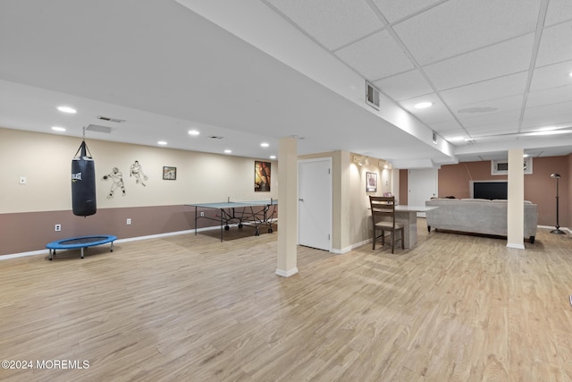 interior space with a paneled ceiling and light hardwood / wood-style floors