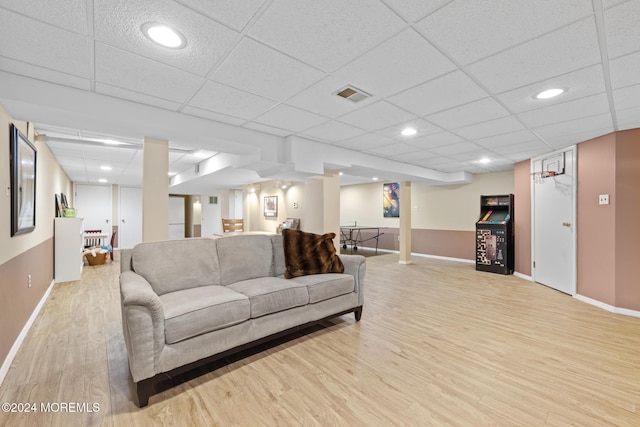 living room featuring a drop ceiling and light wood-type flooring