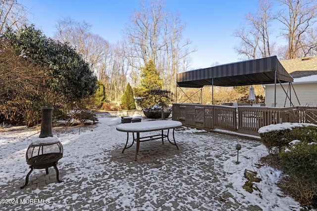 yard covered in snow with an outdoor fire pit and a wooden deck