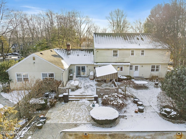 snow covered house with a wooden deck