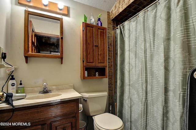 bathroom with walk in shower, vanity, a textured ceiling, and toilet