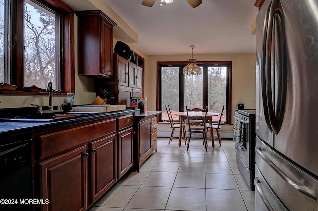 kitchen featuring sink, pendant lighting, light tile patterned floors, black dishwasher, and stainless steel refrigerator