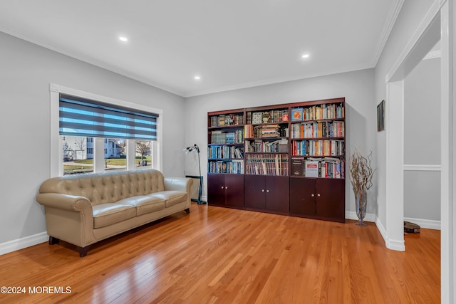 sitting room featuring ornamental molding and light wood-type flooring