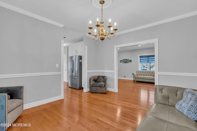 living room featuring light wood-type flooring, an inviting chandelier, and crown molding