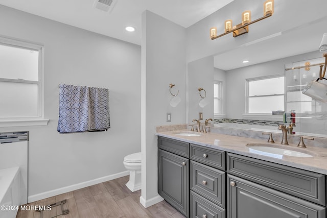 bathroom with vanity, toilet, wood-type flooring, and a tub