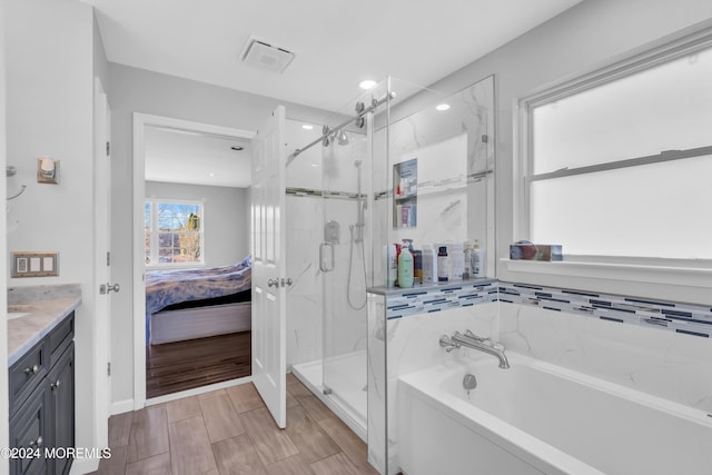 bathroom featuring vanity and independent shower and bath