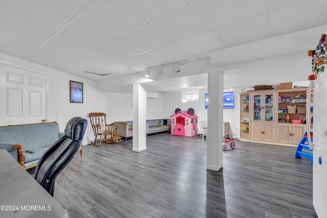 office area with a drop ceiling, dark hardwood / wood-style flooring, and a wall mounted AC