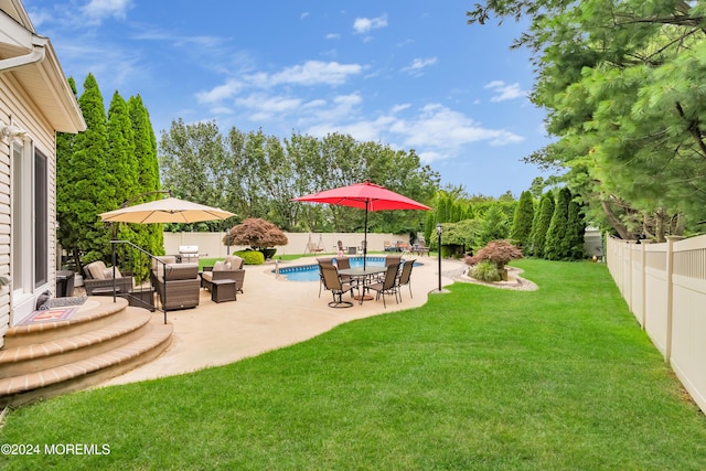 view of yard with outdoor lounge area, a fenced in pool, and a patio