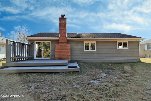 rear view of house featuring a lawn and a wooden deck