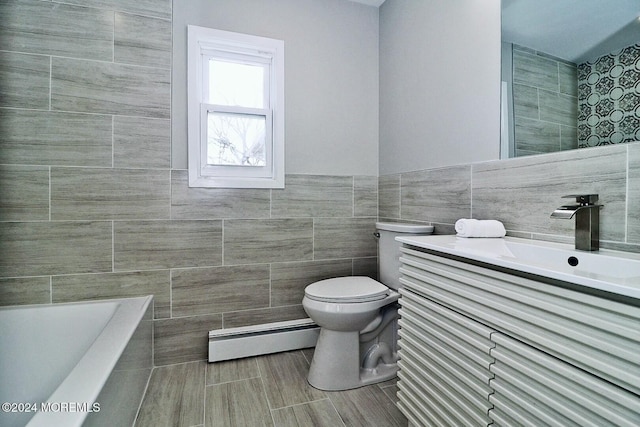 bathroom with a baseboard heating unit, a tub to relax in, toilet, vanity, and tile walls