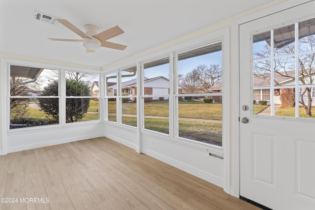 unfurnished sunroom with ceiling fan