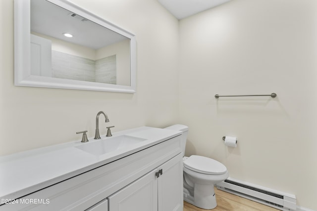 bathroom featuring hardwood / wood-style floors, vanity, toilet, and a baseboard heating unit