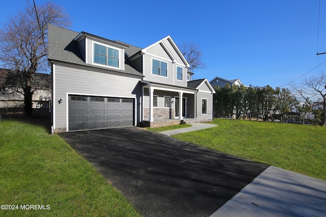 view of front of home with a porch, a garage, and a front yard