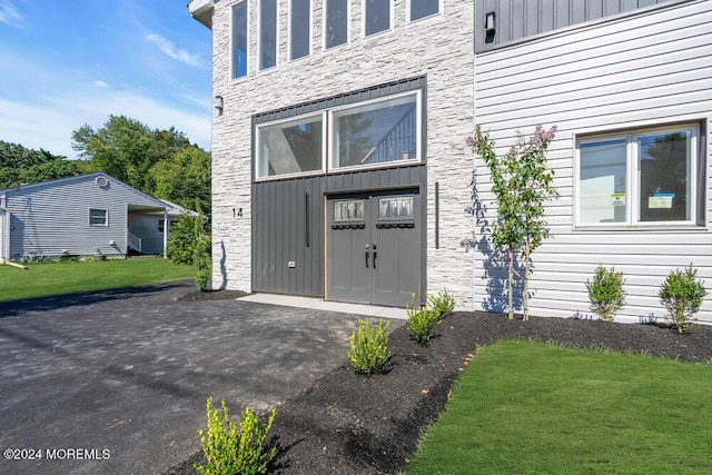 doorway to property with a lawn