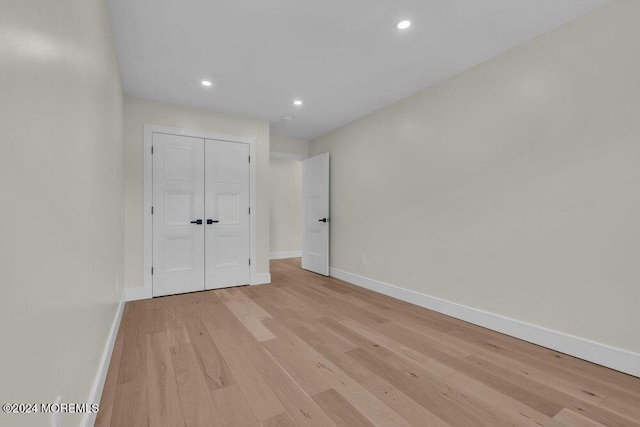 unfurnished bedroom featuring a closet and light hardwood / wood-style flooring