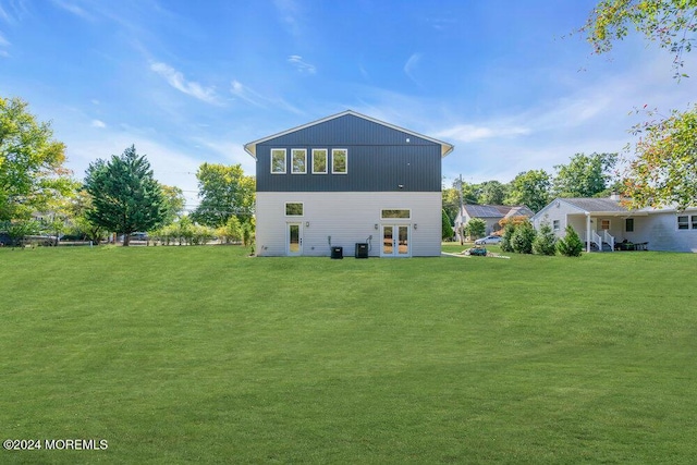 back of property with a lawn and french doors