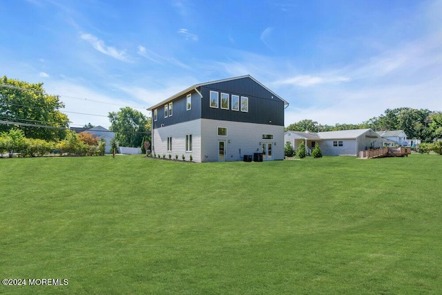 back of house with central air condition unit and a yard