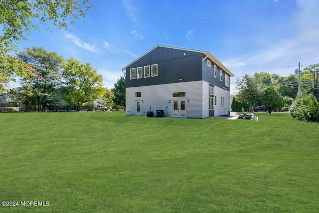 back of house with central AC, a yard, and french doors